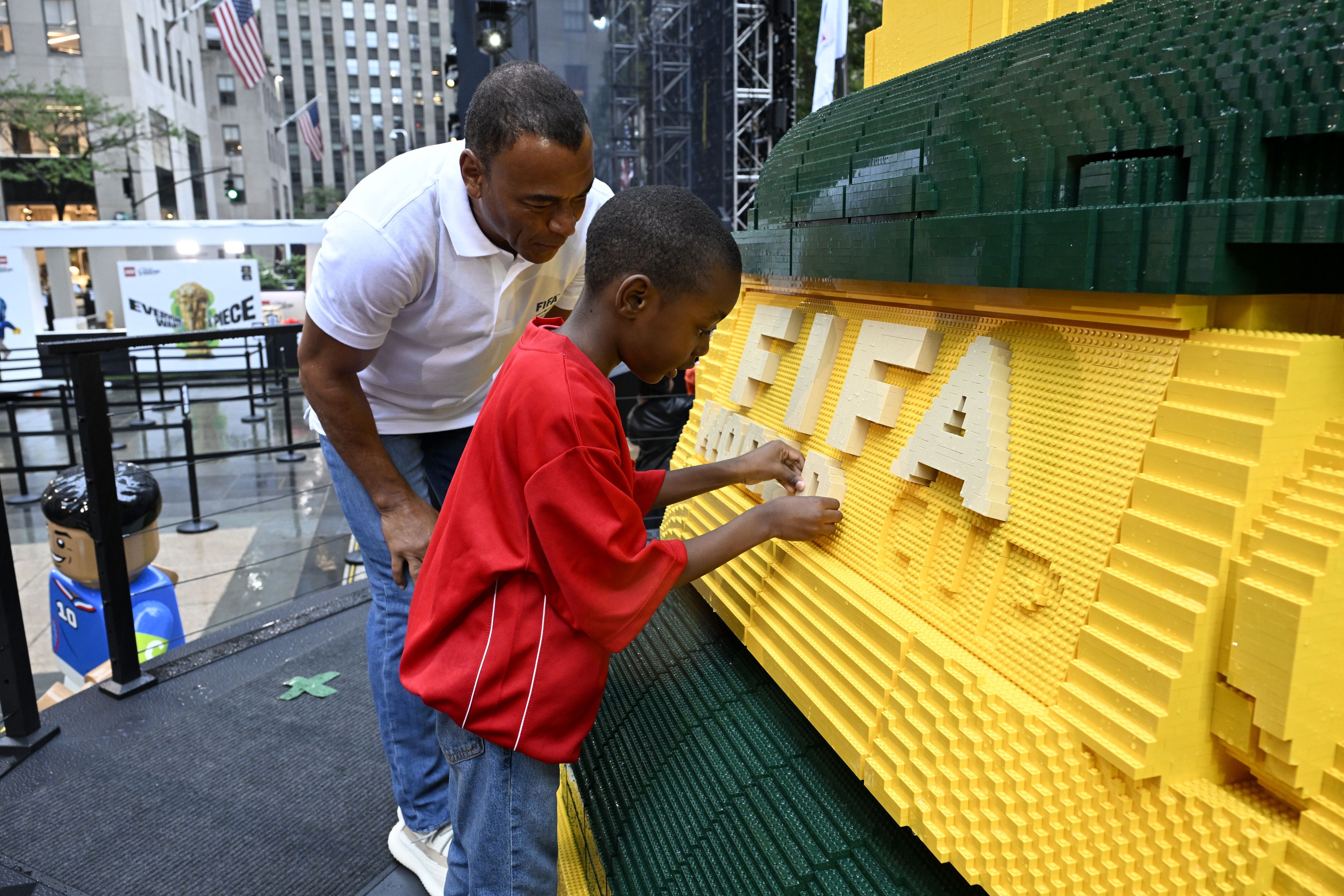 O ex-jogador Cafu e torcedores terminaram de montar o troféu feito com peças Lego • Getty Images for LEGO Group