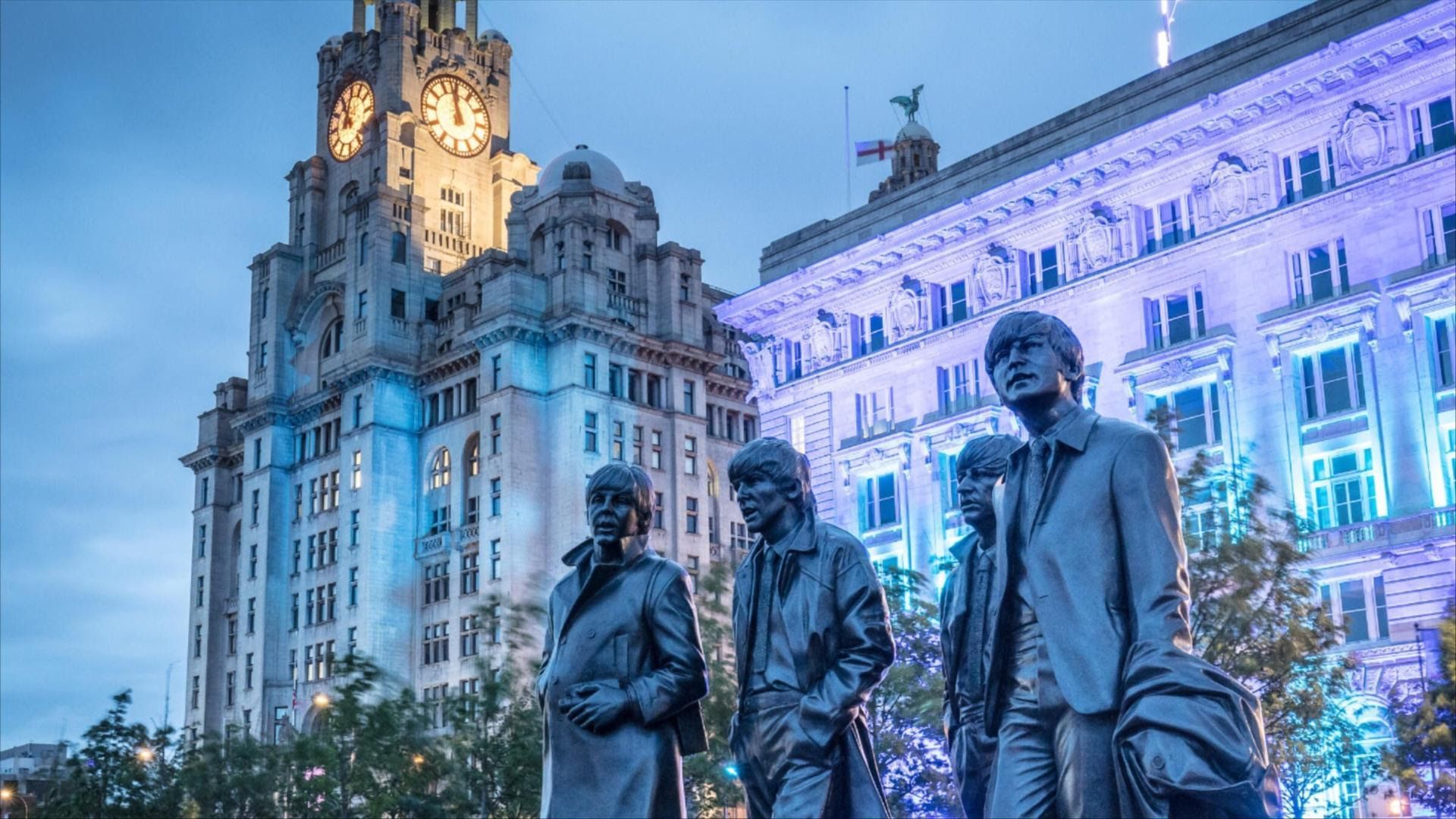 A estátua dos Beatles no Pier Head, em Liverpool, com o Royal Liver Building ao fundo