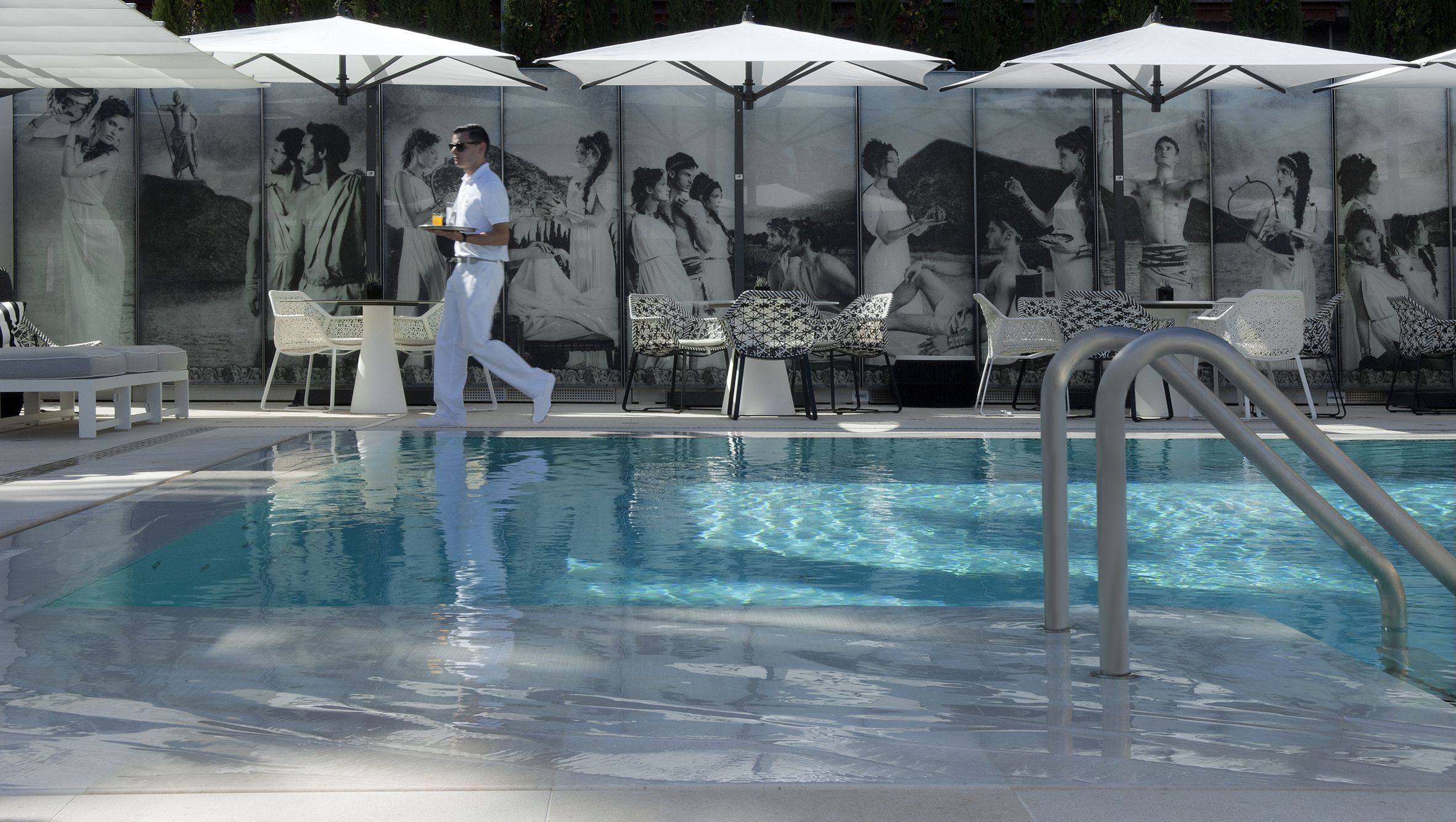 No Hotel Metropole, a área da Odyssey Pool inclui painéis de vidro inspirados na Odisseia • Studio Phenix