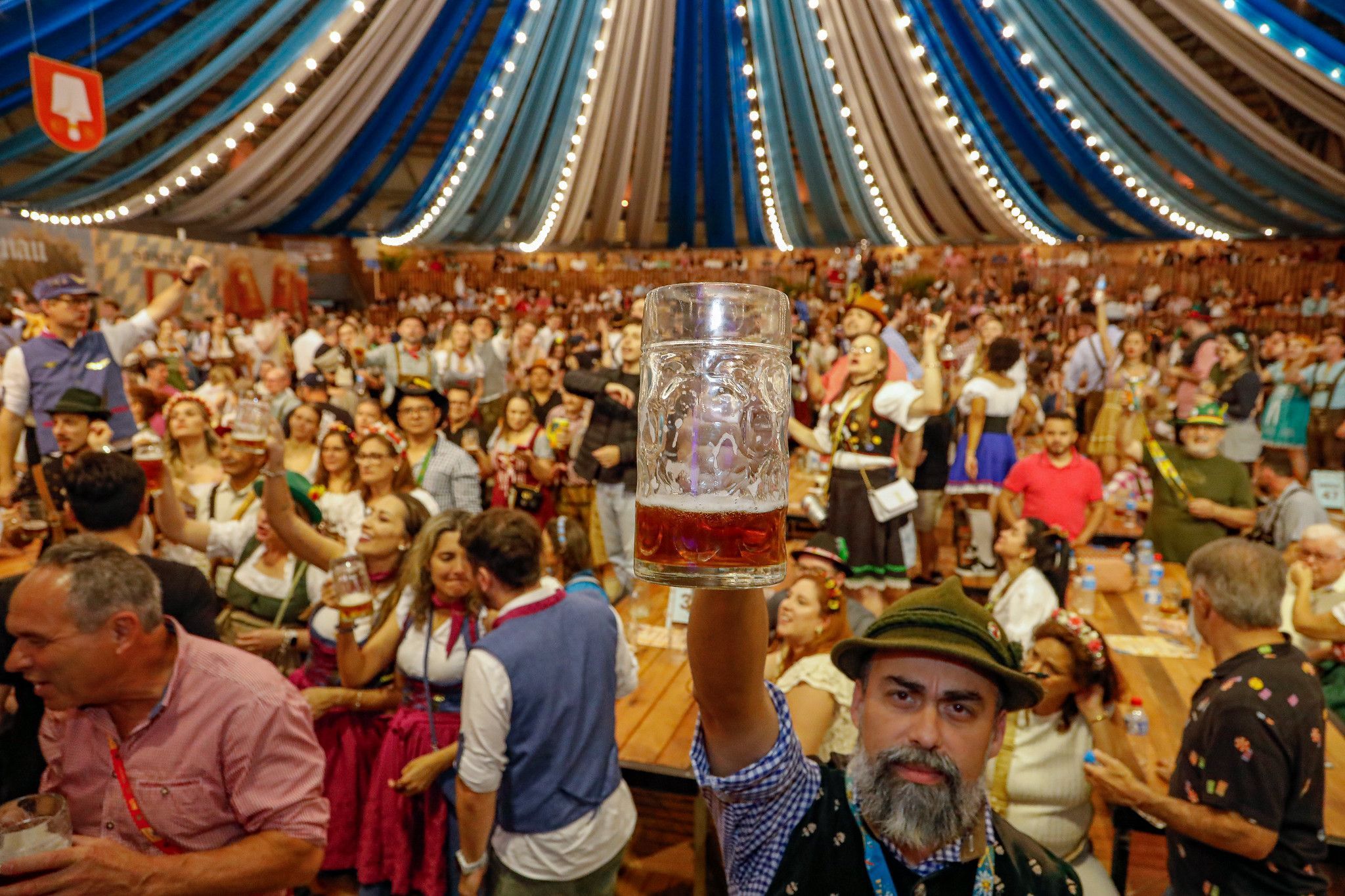 Público celebra em pavilhão festivo durante a Oktoberfest Blumenau de 2025; evento reúne gastronomia, música e chope
